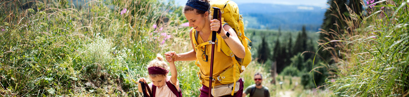 young family hiking in mountains