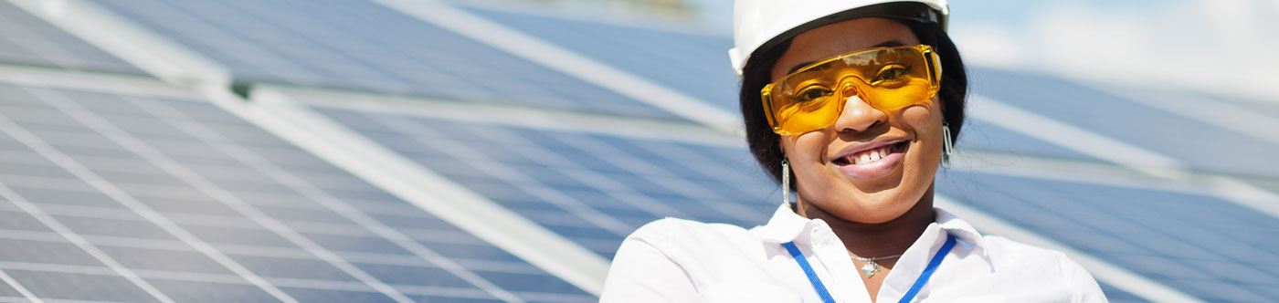 smiling working in front of solar panel